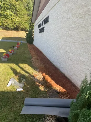 Professional landscaping around house foundation with mulch and edging